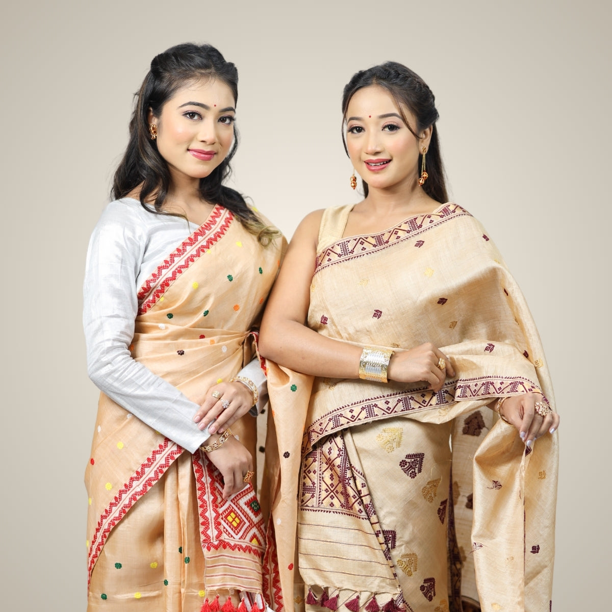 Two women wearing Assamese silk mekhela sadors and wearing Assamese jewellery