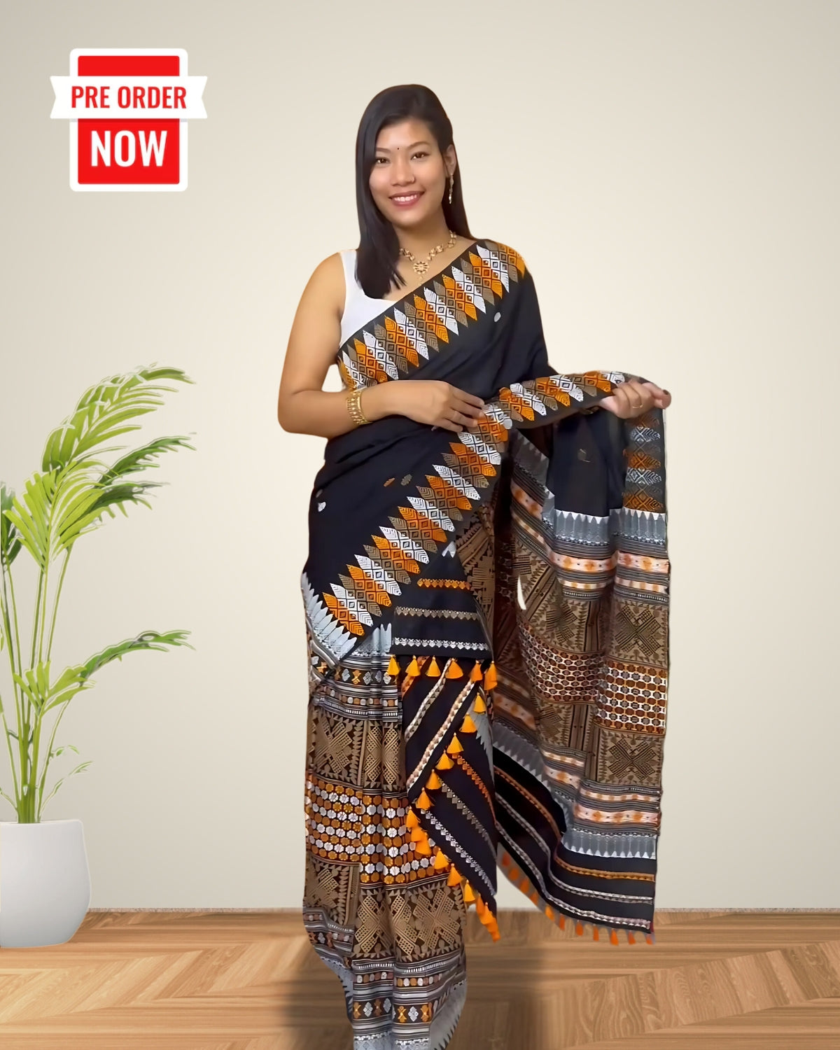 Woman wearing a designer mekhela sador with a pre-order now label on a plain background